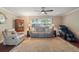 Inviting living room with a large window, comfortable seating, and a decorative rug on the hardwood floor at 5024 37Th E St, Bradenton, FL 34203