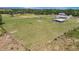Pastoral scene of a large grassy expanse, partially fenced, with a view of the home and outbuildings at 5235 Spencer Parrish Rd, Parrish, FL 34219