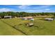 Spacious aerial view of a home with vast green fields, sheds, and outbuildings at 5235 Spencer Parrish Rd, Parrish, FL 34219