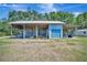 View of metal barn with open bay and covered area on a grassy lot at 5235 Spencer Parrish Rd, Parrish, FL 34219