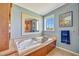 Elegant bathroom features a soaking tub with wood paneling, natural light, and neutral walls at 5235 Spencer Parrish Rd, Parrish, FL 34219