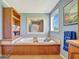 Elegant bathroom features a soaking tub with wood paneling, storage shelves, and neutral walls at 5235 Spencer Parrish Rd, Parrish, FL 34219