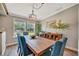 Bright dining room featuring a wooden table, blue chairs, hardwood floors, and lots of natural light at 5235 Spencer Parrish Rd, Parrish, FL 34219