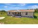 Exterior view features a well-maintained home and a manicured lawn under a bright blue sky at 5235 Spencer Parrish Rd, Parrish, FL 34219