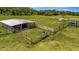 Wide shot of a ranch shows fenced pens, grass and shelter for animals at 5235 Spencer Parrish Rd, Parrish, FL 34219