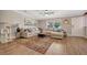 Bright living room with a plush sectional sofa, wood floors, and a decorative area rug at 5235 Spencer Parrish Rd, Parrish, FL 34219