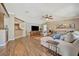 Open-concept living room with wood floors, a large sectional sofa, and a modern entertainment center at 5235 Spencer Parrish Rd, Parrish, FL 34219