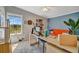 Bright office space featuring a large window, desk, orange sofa, and stylish decor at 5235 Spencer Parrish Rd, Parrish, FL 34219