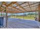 Relaxing covered porch with wood flooring, swing, and view of fenced pasture land at 5235 Spencer Parrish Rd, Parrish, FL 34219
