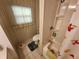 Bathroom features tiled flooring, a toilet, and a shower/tub combination with floral shower curtain at 5408 Chateau Ln, Bradenton, FL 34207