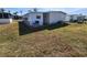 Exterior view of a well-maintained manufactured home with a large grassy lawn and AC unit at 5408 Chateau Ln, Bradenton, FL 34207