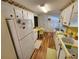 Galley kitchen with white cabinets, yellow countertops, and wood-look flooring at 5408 Chateau Ln, Bradenton, FL 34207