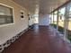 Spacious covered patio with red painted floor and lattice decorative posts on an attractive manufactured home at 5408 Chateau Ln, Bradenton, FL 34207