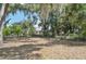 Lush backyard featuring mature trees, grass, and shade at 5414 Ansonia Ter, North Port, FL 34287
