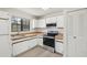 Well-lit kitchen with white cabinets, wooden countertops, and modern appliances at 5414 Ansonia Ter, North Port, FL 34287
