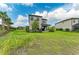 Home exterior with large backyard, including patio, lush green lawn, and landscaped garden at 5583 Summit Gln, Bradenton, FL 34203