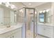 Modern bathroom featuring a glass enclosed shower, dual sinks, and white cabinets with silver hardware at 5583 Summit Gln, Bradenton, FL 34203