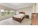 Cozy bedroom featuring a wooden bed frame, carpeted floors, and a window overlooking the serene backyard at 5583 Summit Gln, Bradenton, FL 34203