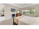 Comfortable bedroom with a queen bed, dresser, plush carpet, and a large window overlooking the serene water view at 5583 Summit Gln, Bradenton, FL 34203