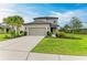Front of a home with a driveway, small palm tree and well-manicured landscaping at 5583 Summit Gln, Bradenton, FL 34203