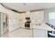 Bright kitchen featuring white cabinetry, stainless steel appliances, and a breakfast bar at 5583 Summit Gln, Bradenton, FL 34203