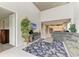 Bright living room featuring high ceilings, tiled floors, TV, and a large seashell patterned area rug at 5583 Summit Gln, Bradenton, FL 34203