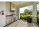 Outdoor kitchen area with stainless steel grill, sink, countertop, and a view of the playground at 5583 Summit Gln, Bradenton, FL 34203