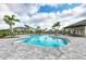 Community pool with paved deck, lounge chairs, palm trees, and a covered area with tables and chairs at 5583 Summit Gln, Bradenton, FL 34203