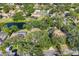 An aerial view of a residential neighborhood, showcasing tree-lined streets, water features, and community pools at 5711 Garden Lakes Fern, Bradenton, FL 34203