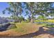 Beautiful backyard with trees, lush green grass, lake view, and screened-in pool at 5711 Garden Lakes Fern, Bradenton, FL 34203