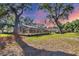Spacious backyard featuring a screened lanai, beautiful lawn, and mature trees at 5711 Garden Lakes Fern, Bradenton, FL 34203