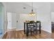Cozy dining area features wood floors, elegant chandelier, and seating for four at 5711 Garden Lakes Fern, Bradenton, FL 34203