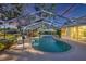 Screened-in pool with a brick trim, complemented by a patio, set in a lush backyard landscape at 5711 Garden Lakes Fern, Bradenton, FL 34203
