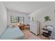 Cozy bedroom with white furniture, light blue bedspread, and window overlooking the outdoor greenery at 6040 Oak Creek Ln # 1822, Bradenton, FL 34210