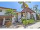 Inviting condo with lush landscaping, mature palm trees, and brown and white exterior paint scheme at 6040 Oak Creek Ln # 1822, Bradenton, FL 34210