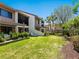 Lush backyard featuring well-kept lawn, patio, and tropical landscaping at 6204 Midnight Pass Rd # 102, Sarasota, FL 34242