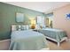 Inviting bedroom with twin beds, featuring nautical-themed décor and natural light from the window at 6204 Midnight Pass Rd # 102, Sarasota, FL 34242