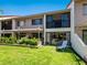 Rear exterior view of a multi-story home with private patio, covered area, and a well-maintained backyard at 6204 Midnight Pass Rd # 102, Sarasota, FL 34242