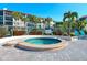 Community hot tub by the pool, surrounded by red flowering plants at 6204 Midnight Pass Rd # 102, Sarasota, FL 34242