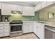 Bright kitchen featuring white cabinets, stainless steel appliances, and a decorative backsplash at 6204 Midnight Pass Rd # 102, Sarasota, FL 34242
