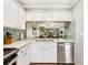 Modern kitchen featuring white cabinetry, updated countertops, stainless steel appliances, and stylish backsplash at 6204 Midnight Pass Rd # 102, Sarasota, FL 34242
