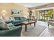 Cozy living room with coastal decor, tile floors, and sliding glass doors to the patio at 6204 Midnight Pass Rd # 102, Sarasota, FL 34242