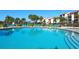 Large outdoor pool with sun loungers, palm trees, and condo buildings at 6204 Midnight Pass Rd # 102, Sarasota, FL 34242