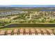 An aerial view showcasing waterfront homes with terracotta roofs surrounded by lush landscaping, lakes, and waterways at 6642 Willowshire Way, Bradenton, FL 34212