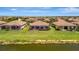 Panoramic aerial view of a row of homes with beautiful green lawns and serene water views at 6642 Willowshire Way, Bradenton, FL 34212