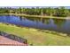 View of the serene lake with mature trees and lush landscaping from this backyard with a screened lanai at 6642 Willowshire Way, Bradenton, FL 34212
