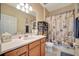 Bright bathroom with wooden cabinets, white countertop, and a starfish-themed shower curtain for a touch of charm at 6642 Willowshire Way, Bradenton, FL 34212