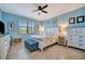 Inviting bedroom with blue walls, ceiling fan, and a window that offers a view of the outdoors at 6642 Willowshire Way, Bradenton, FL 34212