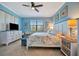 Inviting bedroom with blue walls, ceiling fan, and a window that offers a view of the outdoors at 6642 Willowshire Way, Bradenton, FL 34212