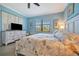 Inviting bedroom with blue walls, ceiling fan, and a window that offers a view of the outdoors at 6642 Willowshire Way, Bradenton, FL 34212